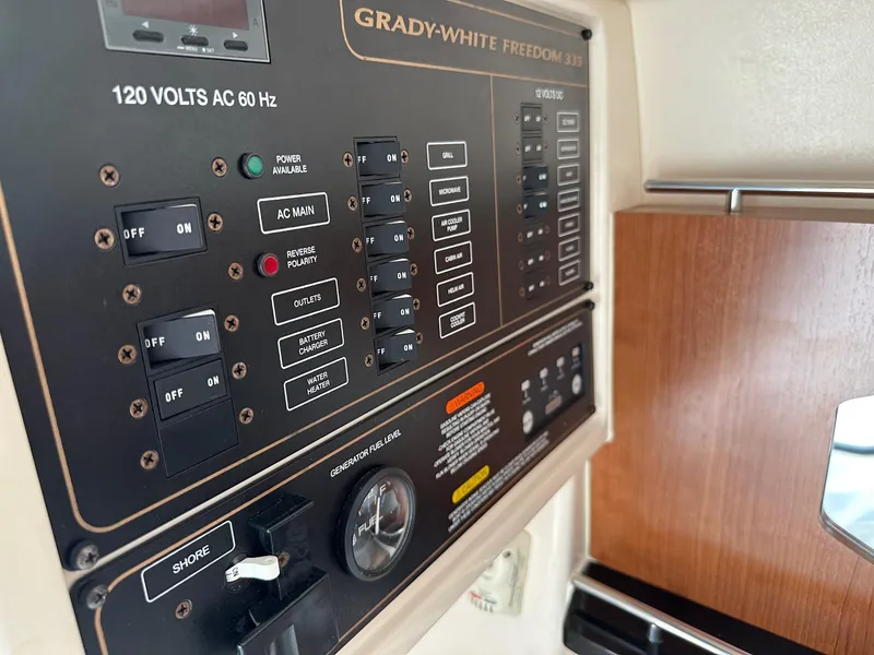 Slide: The Image of Control panel of 2014 Grady-White Freedom 335 boat, featuring various switches and gauges. - 16