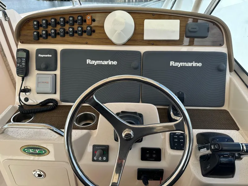 Slide: The Image of 2014 Grady-White Freedom 335 boat dashboard with Raymarine electronics and steering wheel. - 19