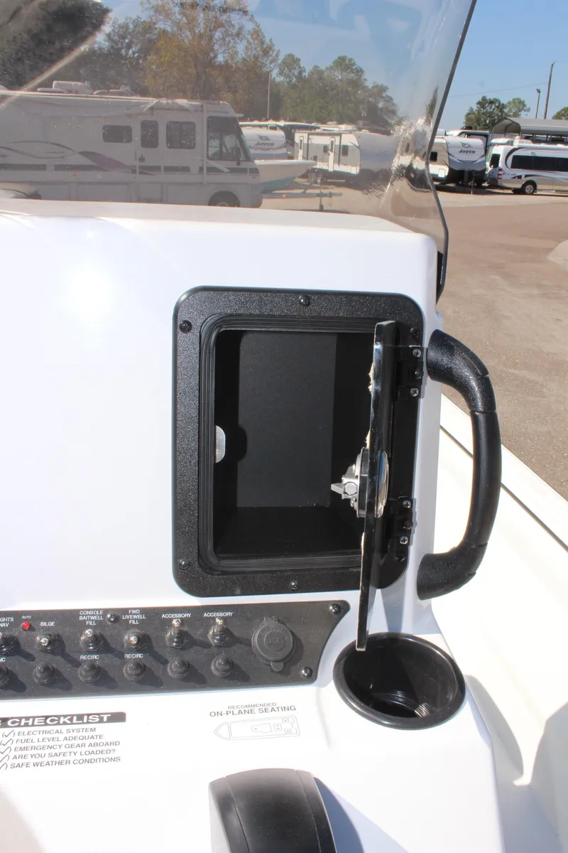 Slide: The Image of 2025 Avid 18 Rogue CC boat dashboard with controls and storage compartment. - 12