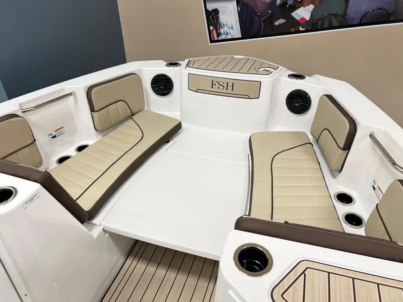 Slide: The Image of 2025 Yamaha Boats 222 FSH Sport E interior with beige seating and cup holders. - 7
