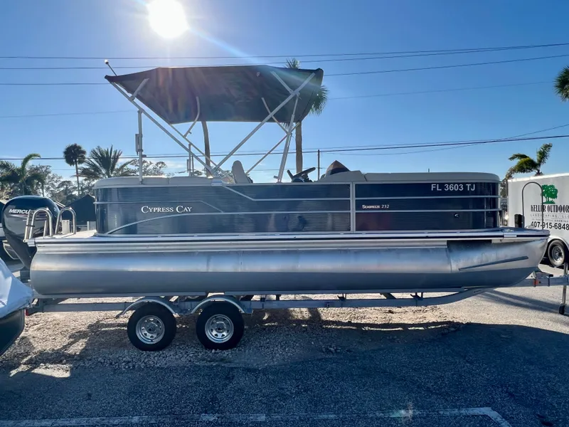 Slide: The Image of 2023 Cypress Cay Seabreeze 232 pontoon boat on trailer, sunny day. - 0
