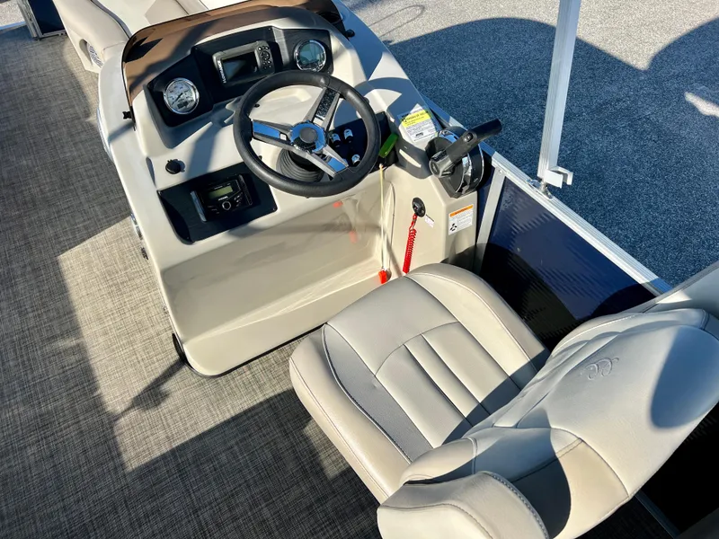 Slide: The Image of 2023 Cypress Cay Seabreeze 232 boat helm with steering wheel and controls. - 11
