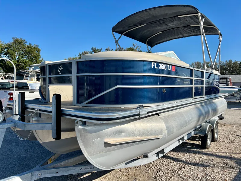 Slide: The Image of 2023 Cypress Cay Seabreeze 232 pontoon boat on trailer, blue exterior, parked outdoors. - 3