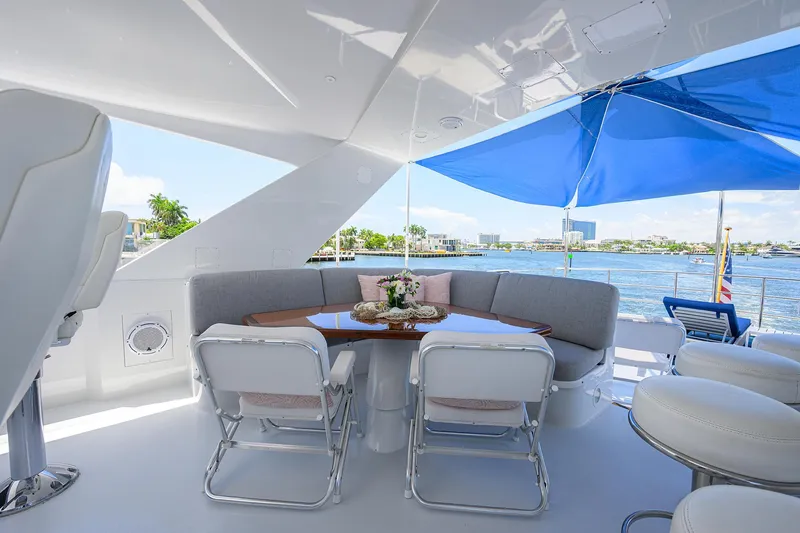 Slide: The Image of Luxurious 1998 Westport Westbay Sonship yacht deck with seating, table, and blue umbrella. - 40