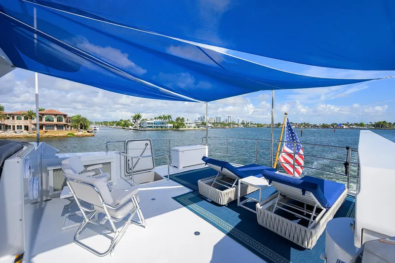 Slide: The Image of Luxurious 1998 Westport Westbay Sonship yacht deck with sun loungers and blue canopy. - 45