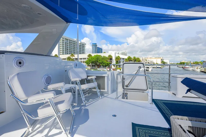 Slide: The Image of 1998 Westport Westbay Sonship yacht deck with chairs, blue canopy, and waterfront view. - 46