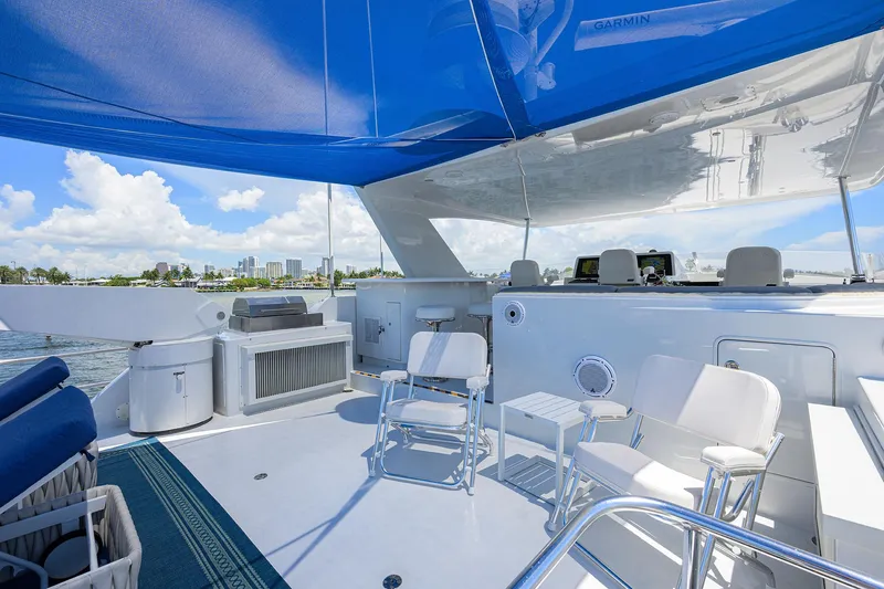 Slide: The Image of Luxurious 1998 Westport Westbay Sonship yacht deck with seating under blue canopy. - 48