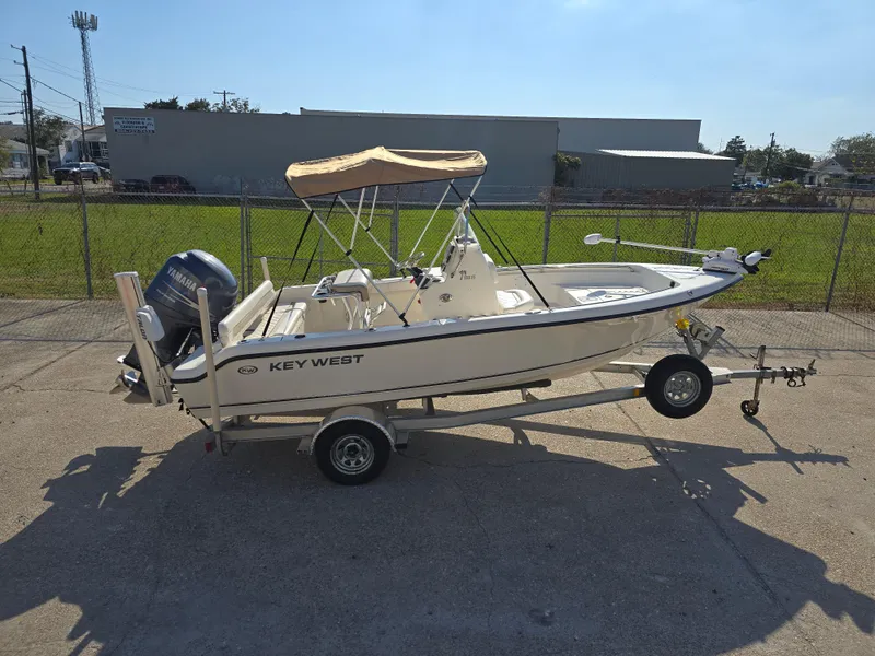Slide: The Image of 2012 Key West 189 FS boat on trailer with canopy, parked outdoors. - 10