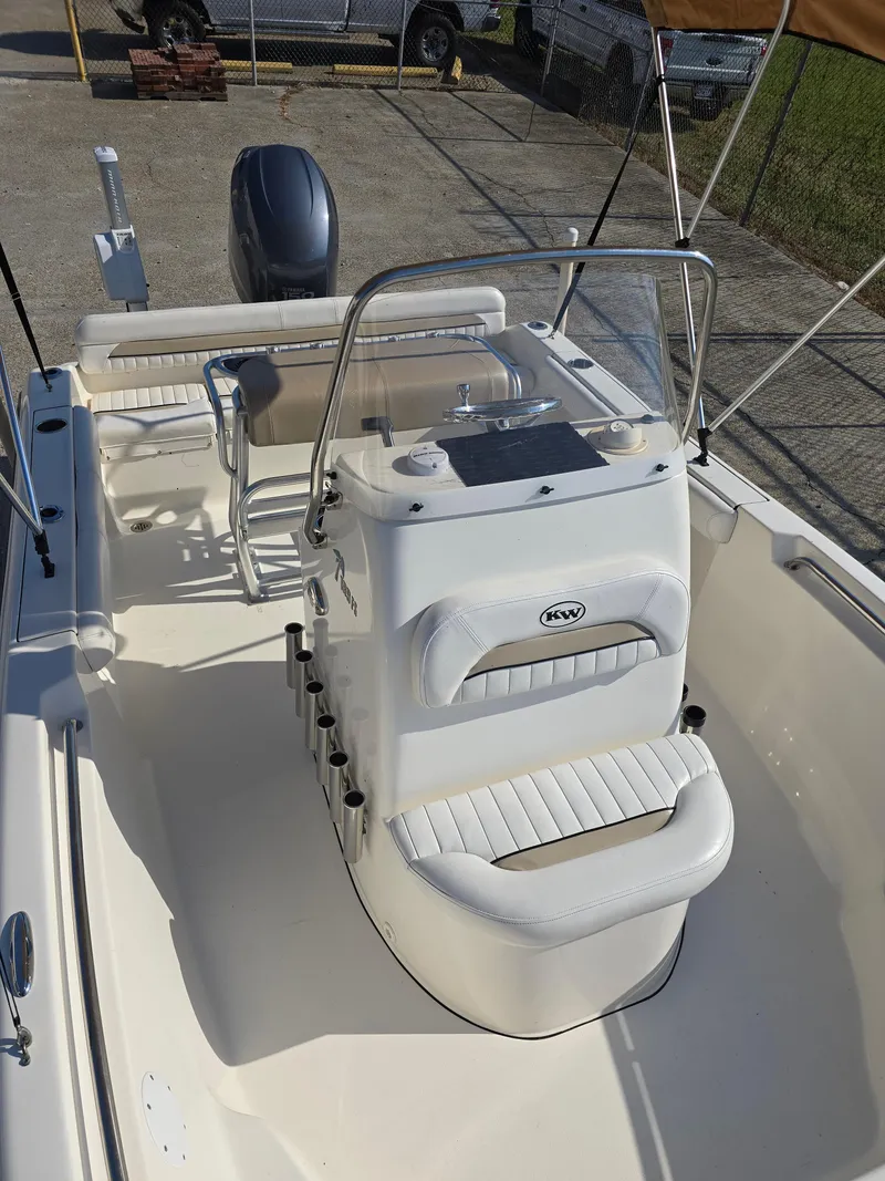 Slide: The Image of 2012 Key West 189 FS boat interior with seating and console, parked outdoors. - 11