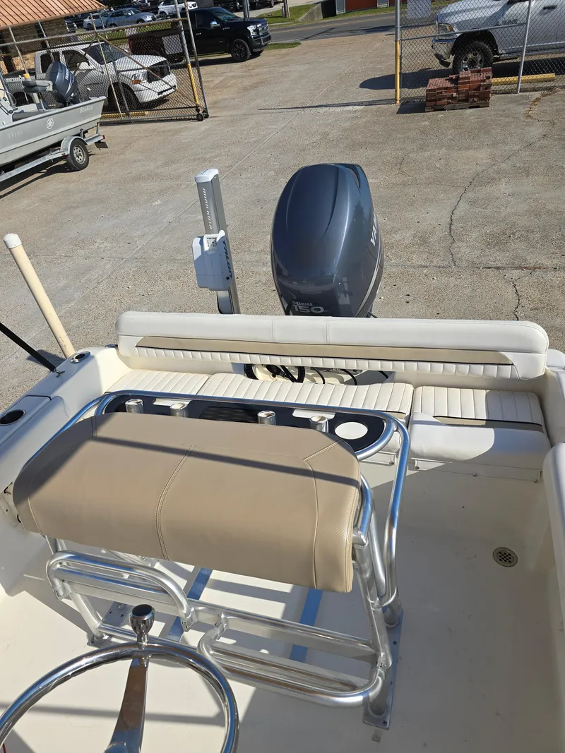 Slide: The Image of 2012 Key West 189 FS boat interior with seating and motor, parked in a lot. - 14