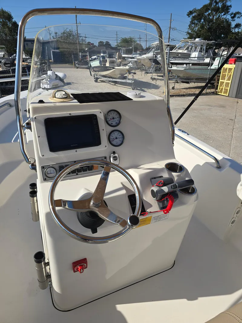 Slide: The Image of 2012 Key West 189 FS boat console with steering wheel and gauges in a marina setting. - 15