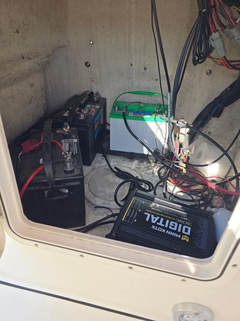 Slide: The Image of 2012 Key West 189 FS boat battery compartment with wiring and charger. - 18