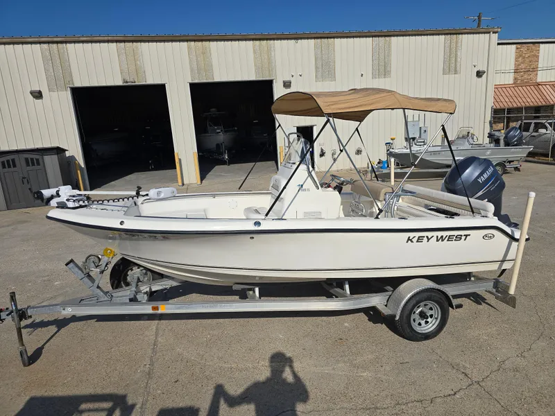 Slide: The Image of 2012 Key West 189 FS boat on trailer, parked outside a warehouse. - 6