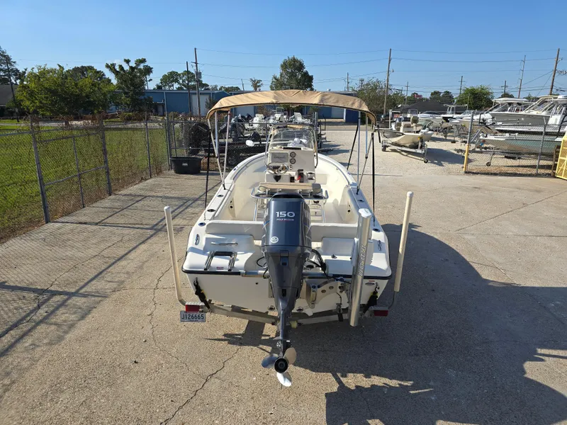 Slide: The Image of 2012 Key West 189 FS boat with outboard motor, parked in a sunny marina. - 8
