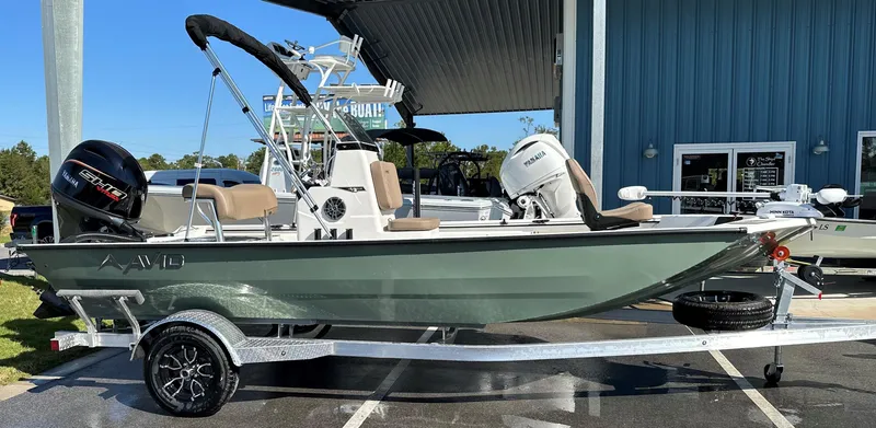 The Image of 2025 Avid 18 Rogue boat on trailer, parked outside a blue building. - 0