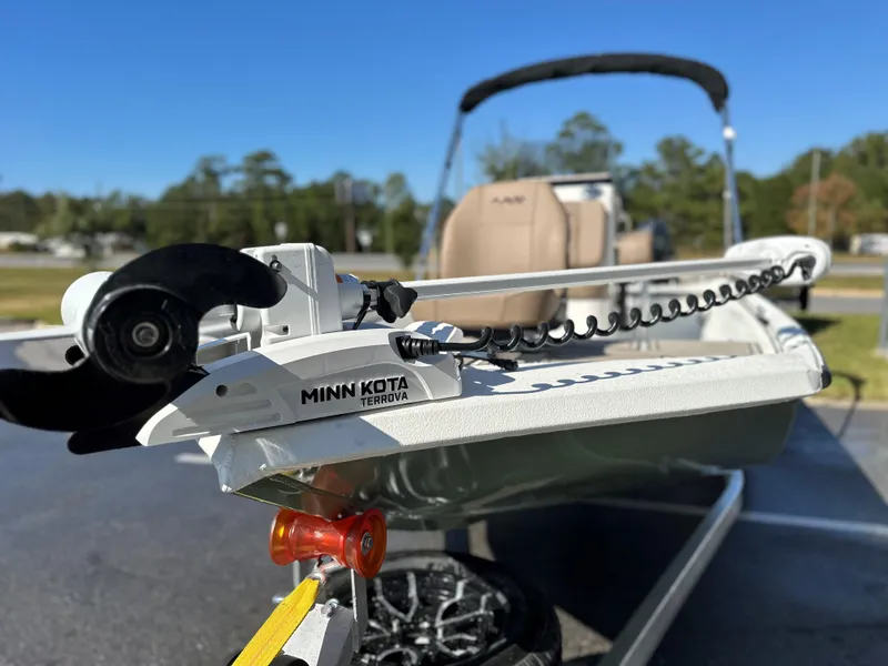 Slide: The Image of Avid 18 Rogue 2025 boat with Minn Kota Terrova motor, parked outdoors. - 16