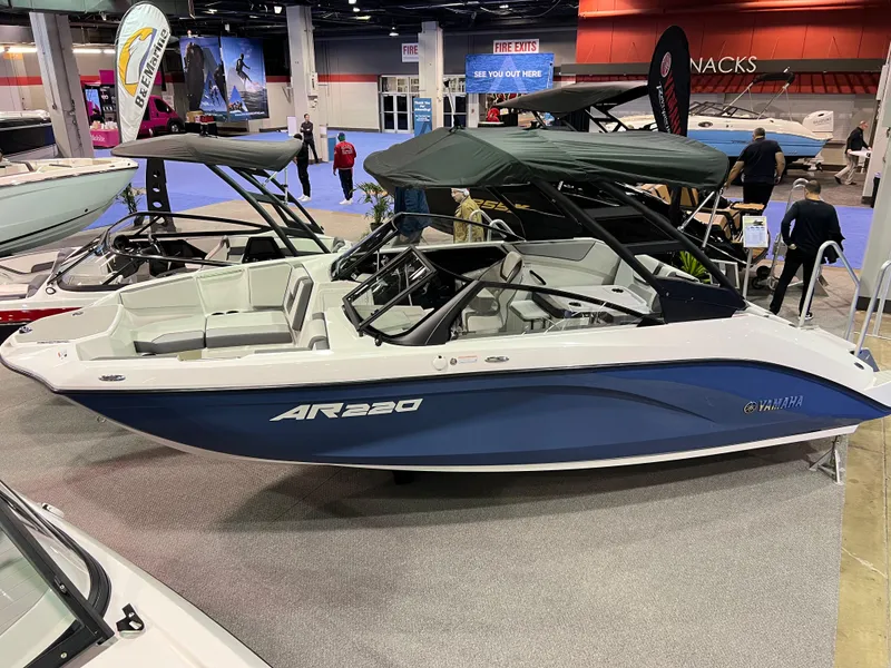 Slide: The Image of 2025 Yamaha Boats AR220 displayed at a boat show, featuring sleek design and modern amenities. - 0