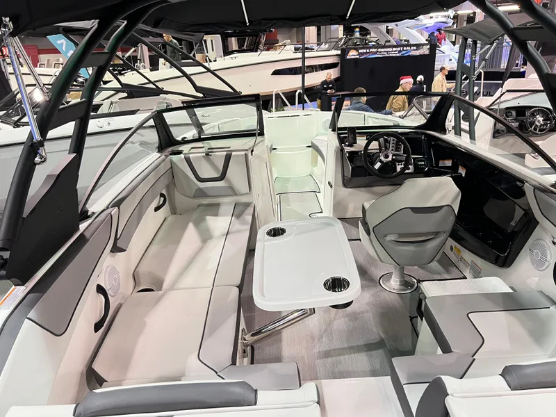 Slide: The Image of 2025 Yamaha Boats AR220 interior with seating, table, and steering console. - 2