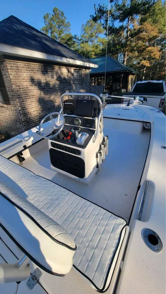 Slide: The Image of 2005 Young Boats 20 model, white interior, parked near a brick house. - 2