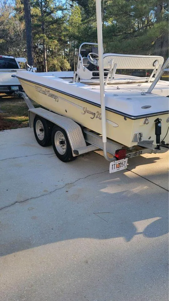 Slide: The Image of 2005 Young Boats 20 on trailer, parked outdoors in a wooded area. - 4