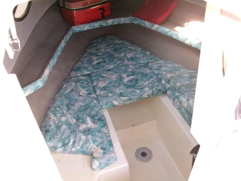 Slide: The Image of 1999 Seaswirl Striper 2600wa cabin interior with patterned bedding and life jackets. - 10