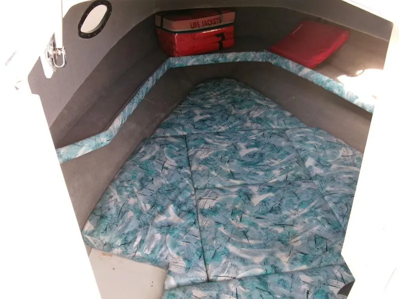 Slide: The Image of 1999 Seaswirl Striper 2600wa cabin interior with life jackets and patterned bedding. - 11