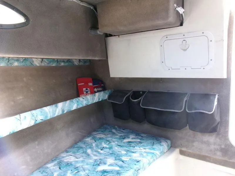 Slide: The Image of 1999 Seaswirl Striper 2600wa cabin interior with storage and patterned bedding. - 12