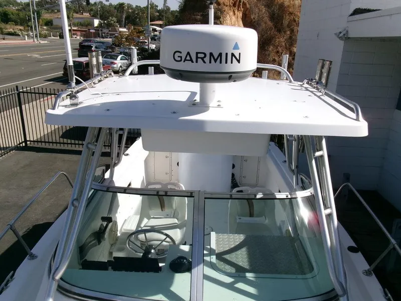 Slide: The Image of 1999 Seaswirl Striper 2600wa boat with Garmin radar, docked near a road. - 16