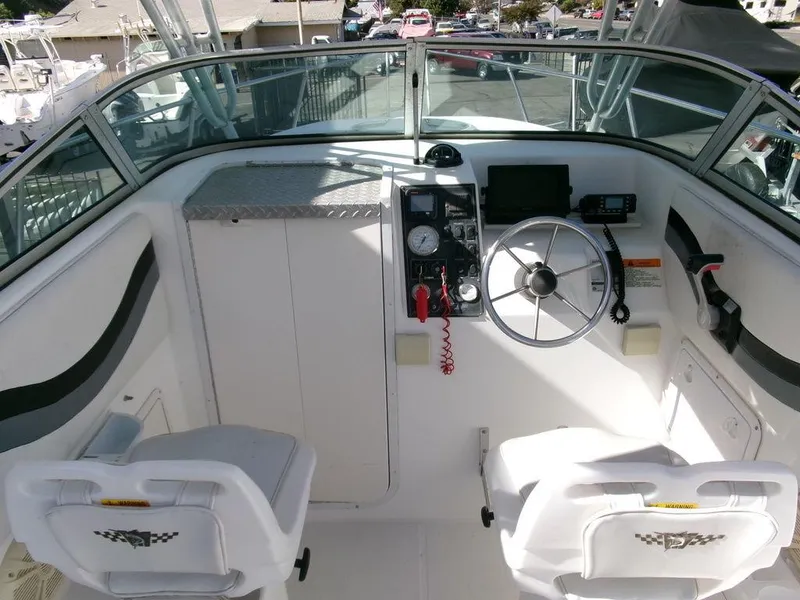 Slide: The Image of 1999 Seaswirl Striper 2600wa boat cockpit with steering wheel and seating. - 6