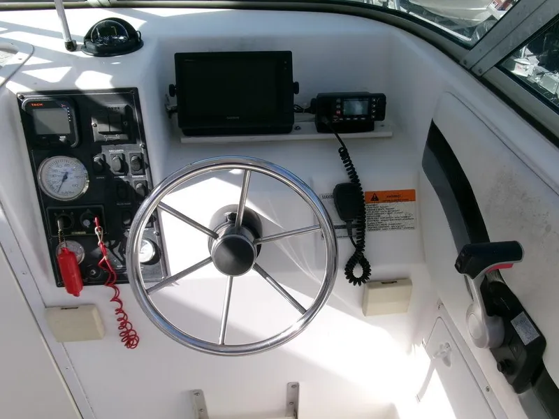 Slide: The Image of 1999 Seaswirl Striper 2600wa boat dashboard with steering wheel and navigation instruments. - 7