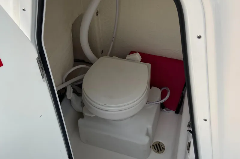 Slide: The Image of 2022 Tidewater 232 LXF boat interior with compact marine toilet. - 10