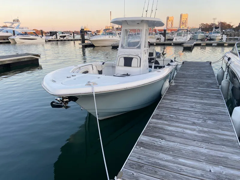 Slide: The Image of 2022 Tidewater 232 LXF boat docked at marina during sunset. - 2
