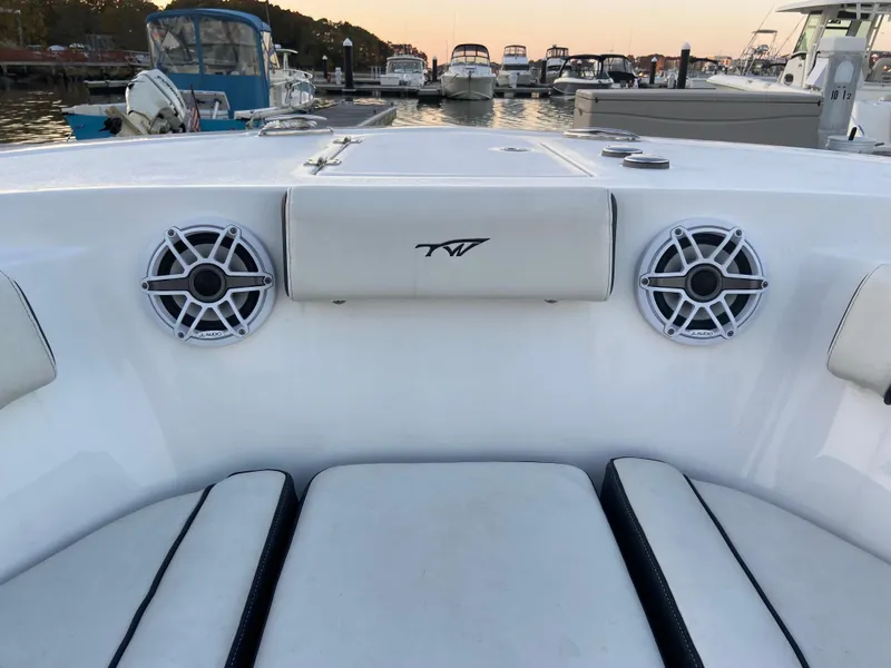 Slide: The Image of 2022 Tidewater 232 LXF boat interior with speakers, docked at marina during sunset. - 4