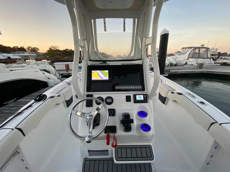 Slide: The Image of 2022 Tidewater 232 LXF boat dashboard with steering wheel and navigation screen at marina. - 7