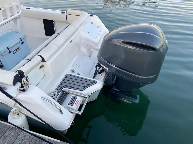 Slide: The Image of 2022 Tidewater 232 LXF boat with outboard motor, docked on calm water. - 9