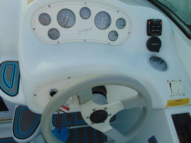 Slide: The Image of Dashboard of a 1995 Baja 272 boat with steering wheel and gauges. - 10