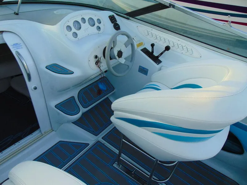 Slide: The Image of Interior of a 1995 Baja 272 boat with white and blue seating and dashboard. - 8