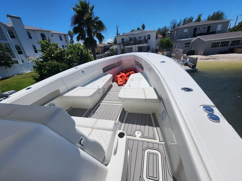 Slide: The Image of 2017 SeaVee 390Z boat with white seating, docked near waterfront homes. - 13
