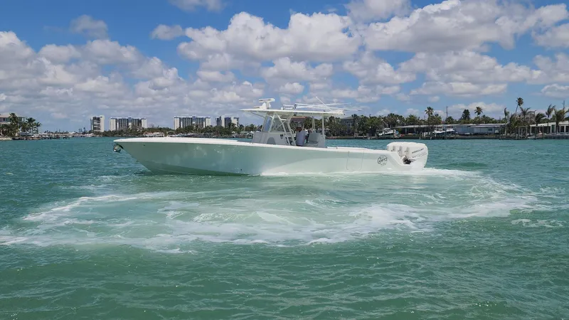 Slide: The Image of 2017 SeaVee 390Z boat cruising on turquoise water under a partly cloudy sky. - 2