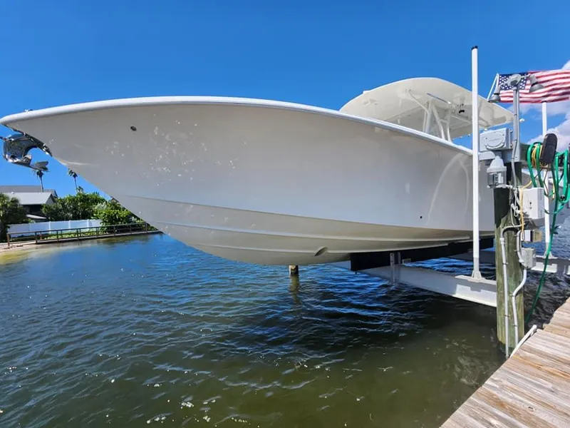 Slide: The Image of 2017 SeaVee 390Z boat on lift, docked by waterfront under clear blue sky. - 8