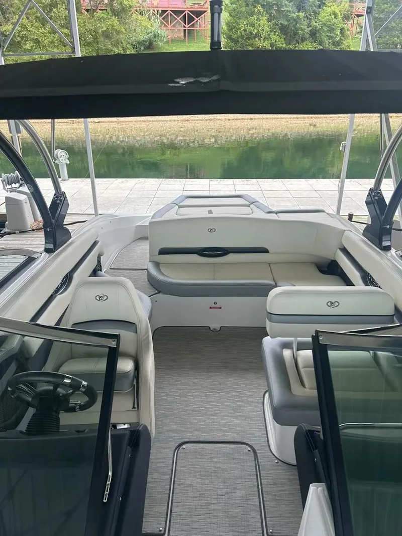 Slide: The Image of 2021 Cobalt CS23 boat interior with seating, docked by a serene lake. - 14