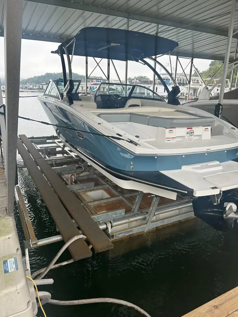 Slide: The Image of 2021 Cobalt CS23 boat docked in a marina with a blue canopy. - 15