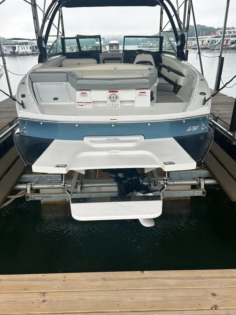 Slide: The Image of 2021 Cobalt CS23 boat docked, rear view with swim platform and seating. - 16