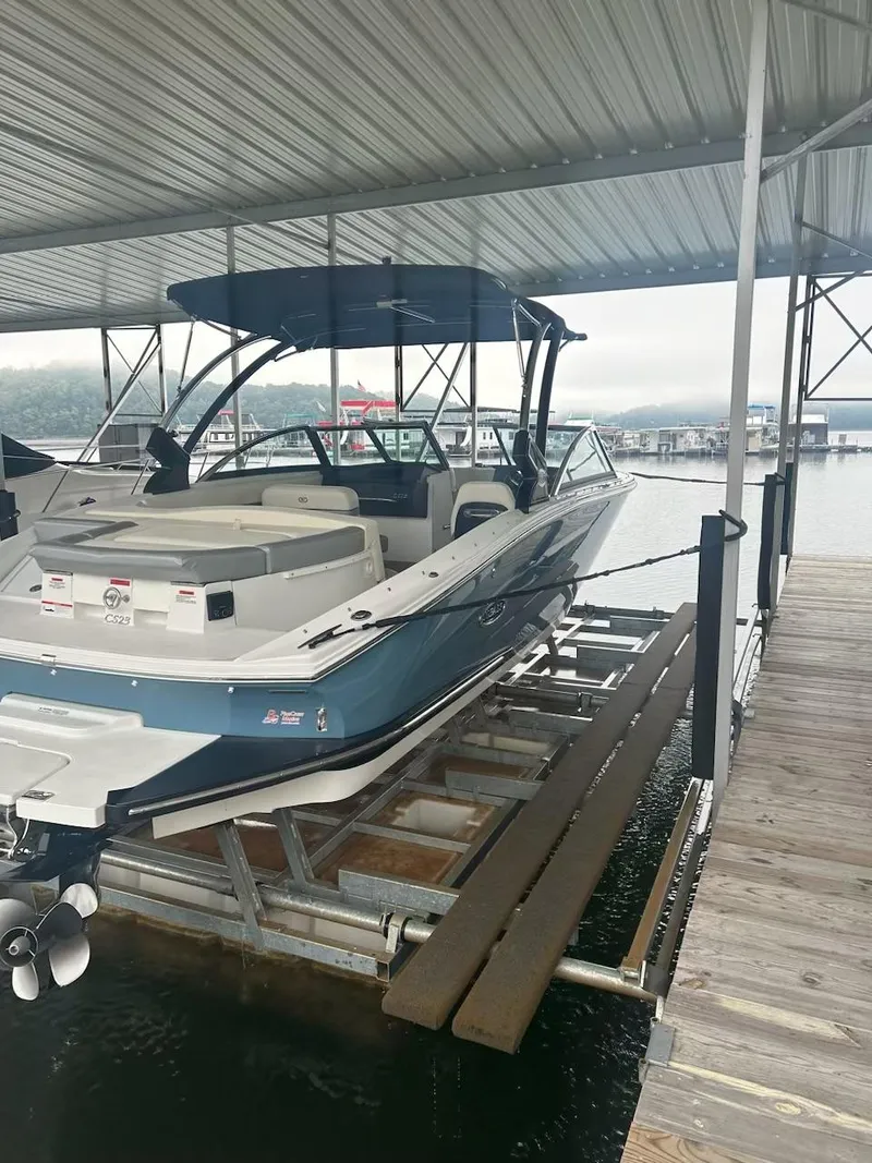 Slide: The Image of 2021 Cobalt CS23 boat docked under covered marina. - 17