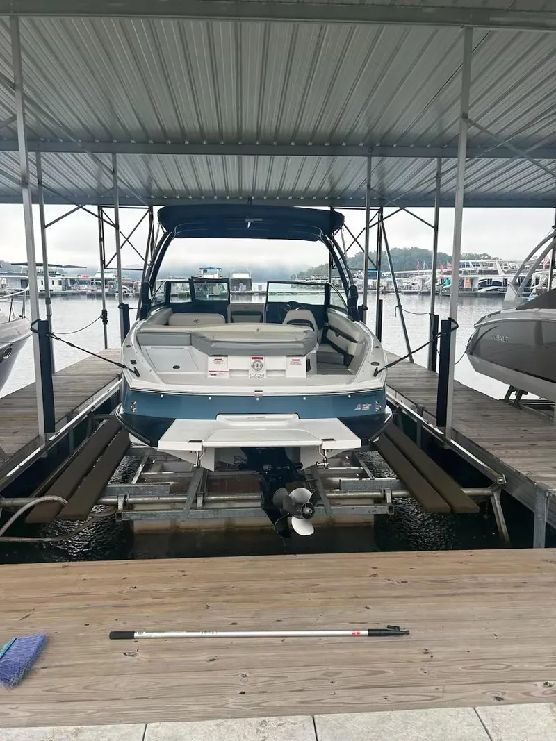 Slide: The Image of 2021 Cobalt CS23 boat docked in a marina under a covered slip. - 19