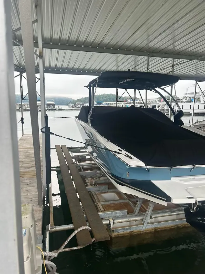 Slide: The Image of 2021 Cobalt CS23 boat docked under a covered marina. - 2