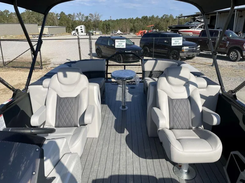 Slide: The Image of 2025 Starcraft SLS-3 boat interior with plush seating and table, parked outdoors. - 11
