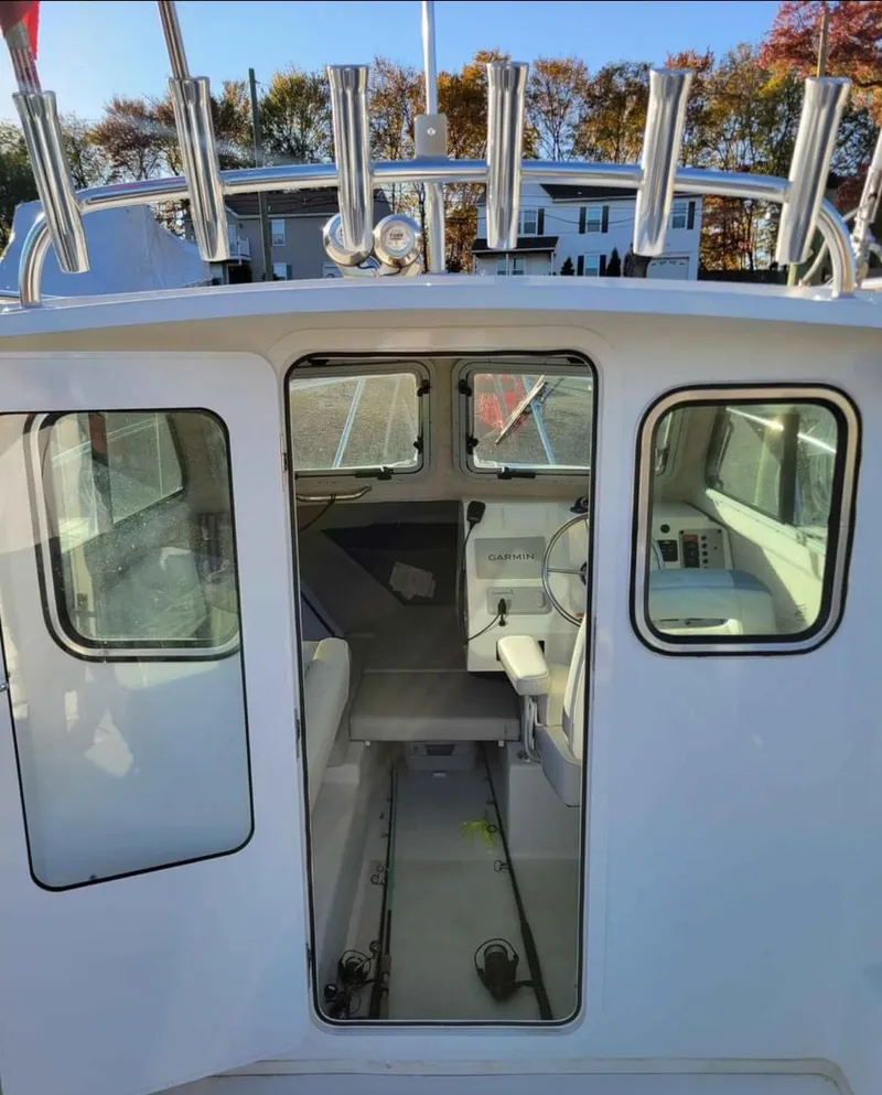 Slide: The Image of 2022 Parker 2320 SL Sport Cabin boat interior with rod holders and seating. - 10