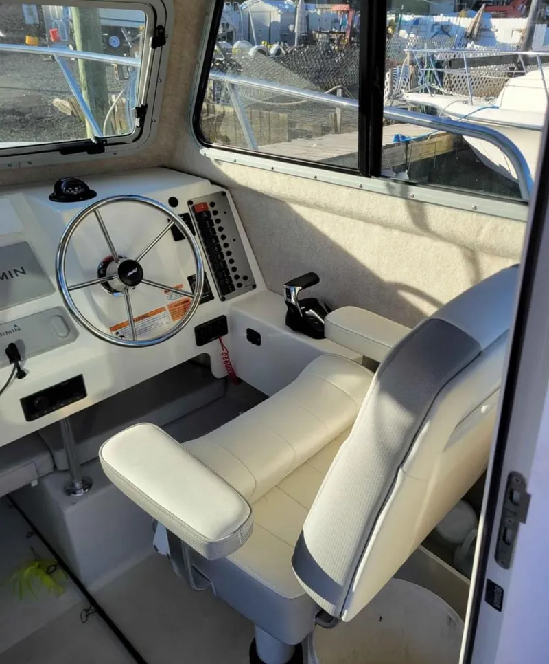 Slide: The Image of 2022 Parker 2320 SL Sport Cabin interior with steering wheel and control panel. - 13