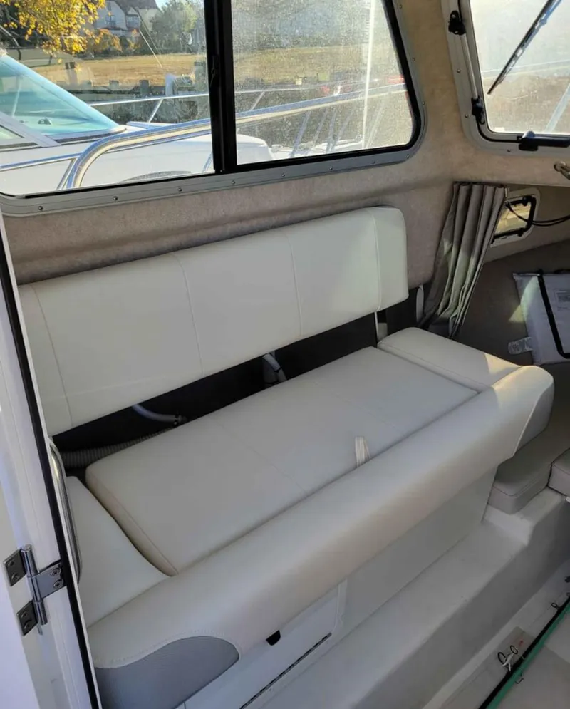 Slide: The Image of 2022 Parker 2320 SL Sport Cabin interior with cushioned seating and window view. - 15
